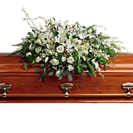 White floral spray on a wooden casket