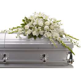 White floral spray arranged on a silver casket