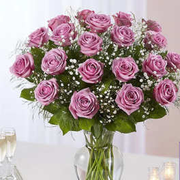 Pink roses arranged in a clear glass vase with baby's breath