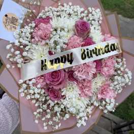 Pink and white bouquet with a birthday ribbon