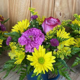 Bright mixed bouquet in a blue mug with yellow daisies and pink roses