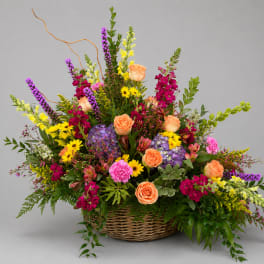 Large mixed flower arrangement in a wicker basket