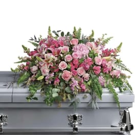 Pink floral casket spray with roses, lilies, and greenery