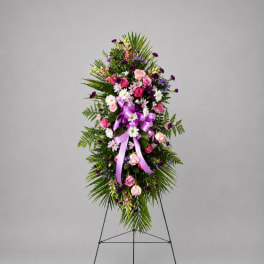 Standing floral spray with pink and purple flowers on a metal easel