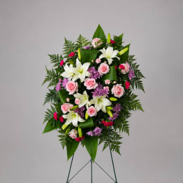 Standing floral spray with pink roses, white lilies, and purple flowers