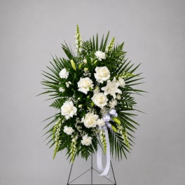 White floral standing spray with roses and lilies on an easel