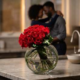 Red rose bouquet in a round glass vase on a countertop