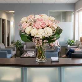 Pink and white roses arranged in a clear glass vase