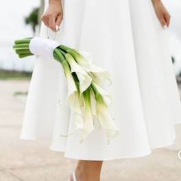 Bride holding a bouquet of white calla lilies