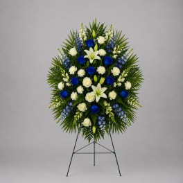 Standing funeral spray with blue and white flowers on an easel