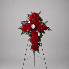 Red floral cross on a metal stand with white and purple accents