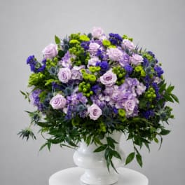 Lavender roses and purple flowers in a white vase