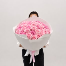 Large bouquet of pink roses wrapped in white paper