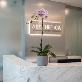 Potted orchid with white and purple flowers on a marble counter