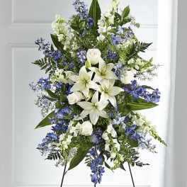 Tall standing floral spray with white lilies and blue flowers