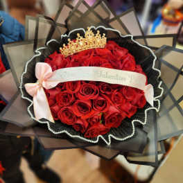 Bouquet of red roses with a gold crown and pink ribbon