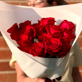Bouquet of red roses wrapped in white paper