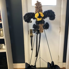 Standing floral cross with yellow roses and black ribbon bows
