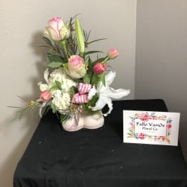 Pink and white floral arrangement in a decorative shoe-shaped container