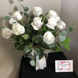 White rose bouquet in a glass vase with eucalyptus