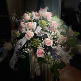 Pink roses in a bouquet with unicorn ribbons and glitter toppers