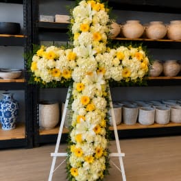 Yellow and white floral cross on a white stand