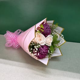 Pink-wrapped bouquet with white roses and purple chrysanthemums