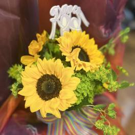 Sunflower bouquet with a striped ribbon and "Super Mom" topper
