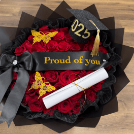 Red rose bouquet with a black graduation cap and diploma scroll