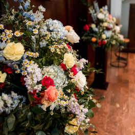 Large mixed floral arrangement with blue, white, pink, and yellow blooms