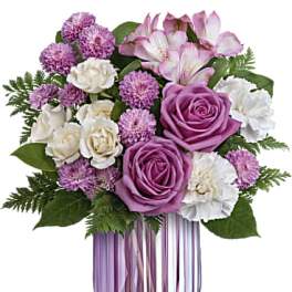 Purple and white bouquet in a lavender glass vase