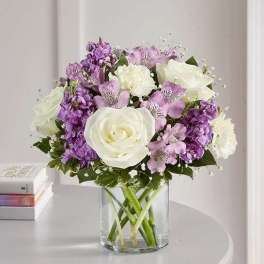 Bouquet of white and purple flowers in a clear glass vase