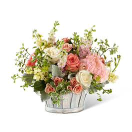 Mixed pink and white roses in a rustic wooden basket