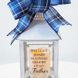 White memorial lantern with a blue plaid bow and a Father remembrance message