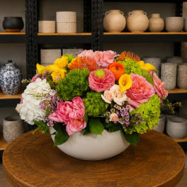 Colorful mixed flower arrangement in a white bowl vase