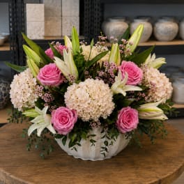Pink roses and cream hydrangeas in a white vase with white lilies