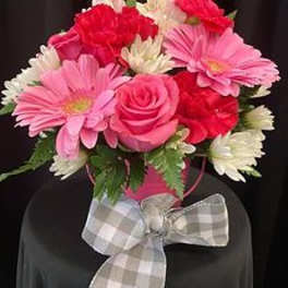 Pink and red bouquet with daisies and roses, tied with a plaid bow