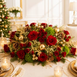 Red rose centerpiece with pinecones and gold ornaments on a table