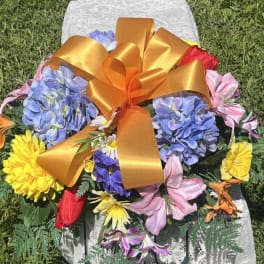 Colorful flower arrangement with a large orange ribbon bow