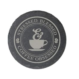 Round slate coaster with a coffee cup graphic and text