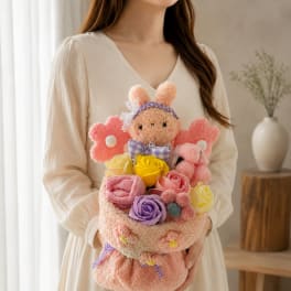 Woman holding a pastel bouquet with a plush bunny and roses