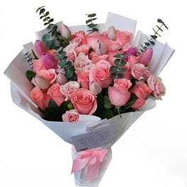 Pink rose bouquet with tulips and eucalyptus wrapped in white paper