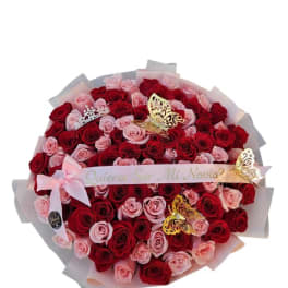 Large bouquet of red and pink roses with butterfly decorations and a ribbon