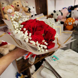 Bouquet of red roses with white baby's breath in wrapped paper