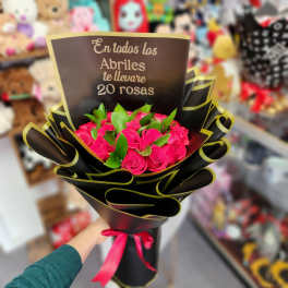 Bouquet of bright pink roses wrapped in black paper with a ribbon