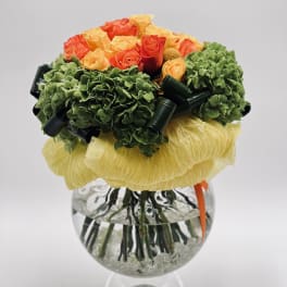 Bouquet of orange and yellow roses in a clear glass vase