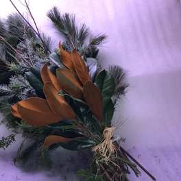 Bundle of evergreen branches with brown magnolia leaves tied together
