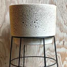 Speckled ceramic planter on a black metal stand