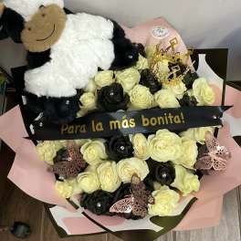 Bouquet of cream and black roses with a plush cow and decorative butterflies