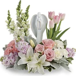 Pink and white floral arrangement with lilies, roses, and tulips